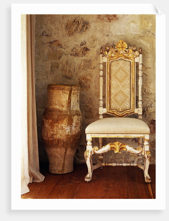 A pot is kept beside a chair against the wall in the house by Anonymous