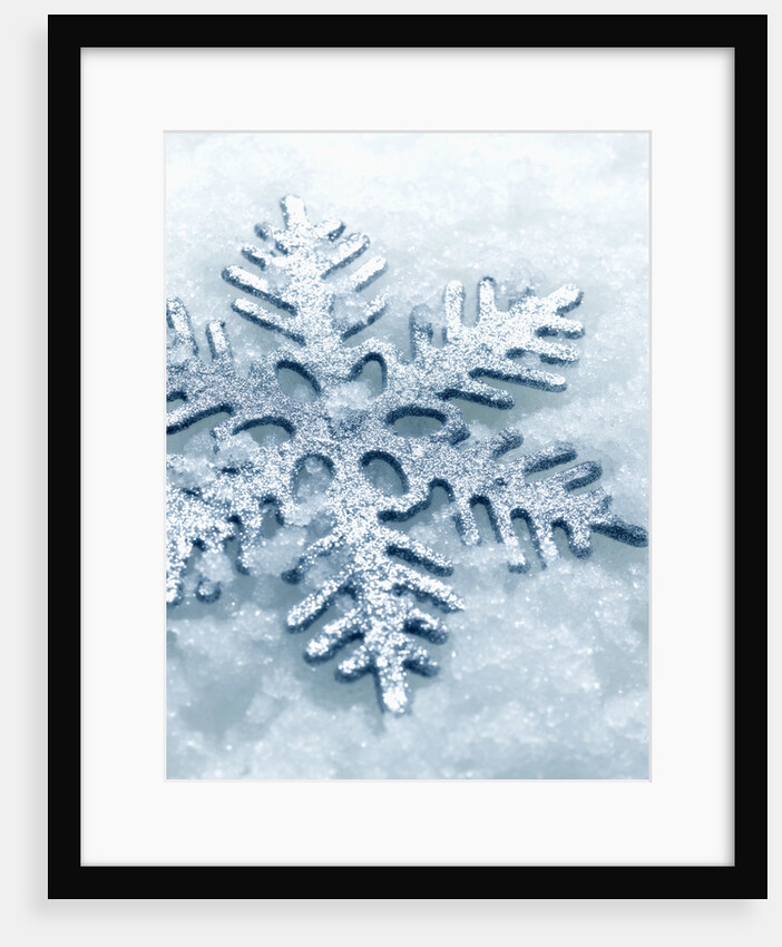 Snowflake Shaped Christmas Ornament Lying in the Snow by Anonymous