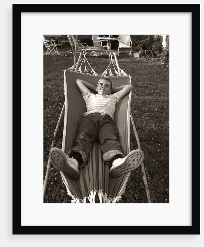 1950s Relaxed Boy Lying In Suburban Backyard Hammock by Anonymous