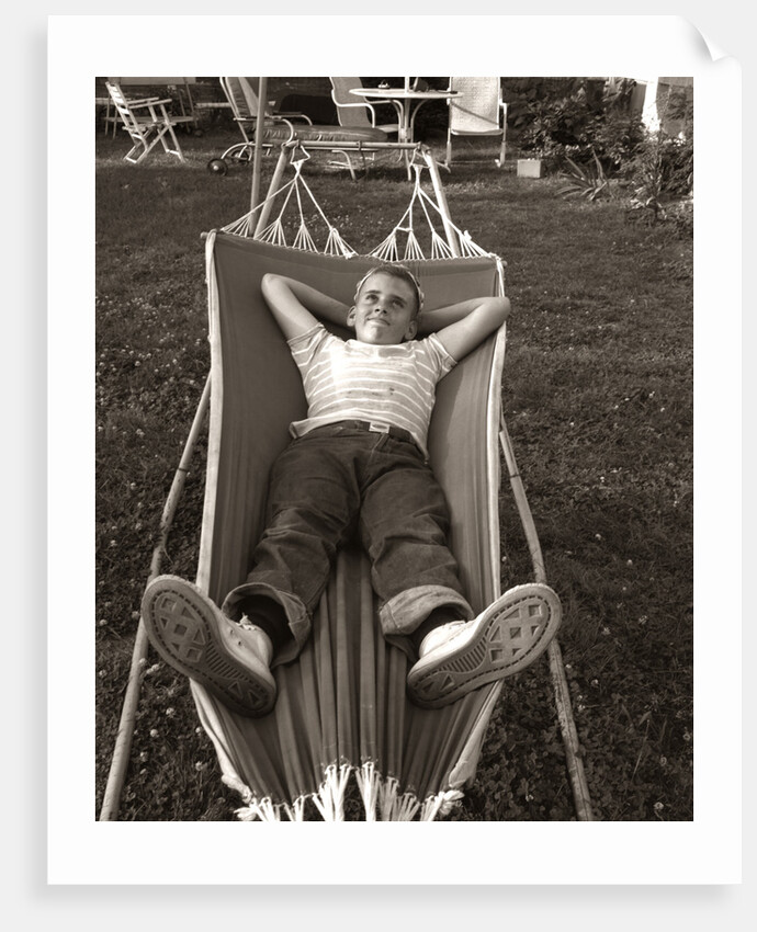 1950s Relaxed Boy Lying In Suburban Backyard Hammock by Anonymous