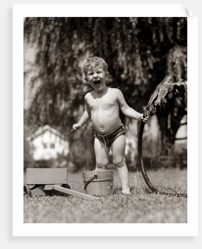1940s 1950s Wet Young Boy Toddler Outside Playing With Water Hose by Anonymous