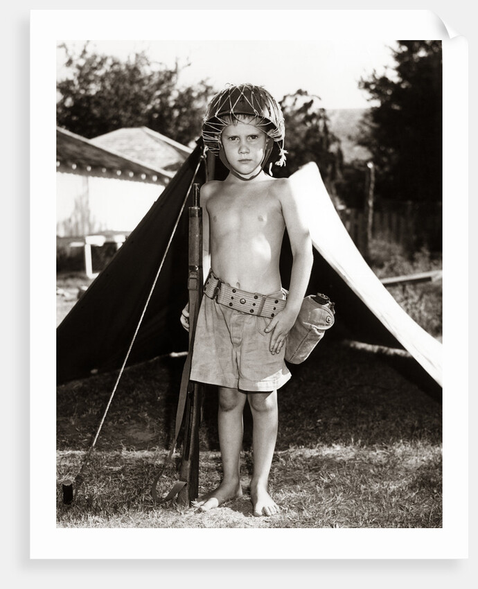 1950s Boy Playing Soldier Standing With Rifle Helmet Canteen Tent by Anonymous