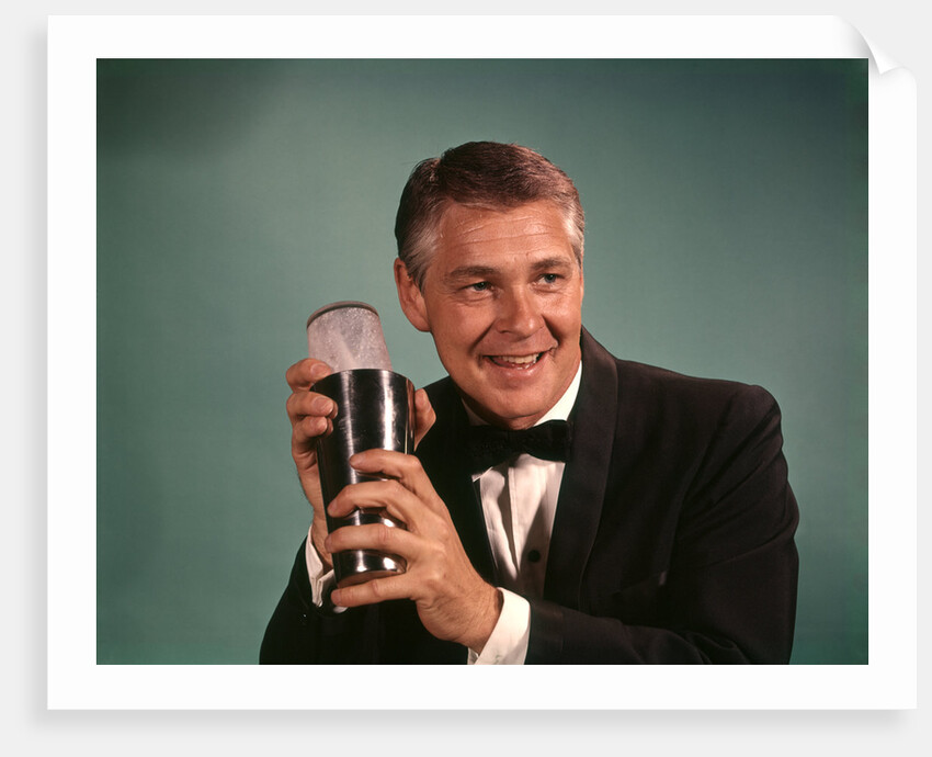 1960s 1970s Bartender Man In Black Tuxedo Mixing Cocktail In Shaker by Anonymous