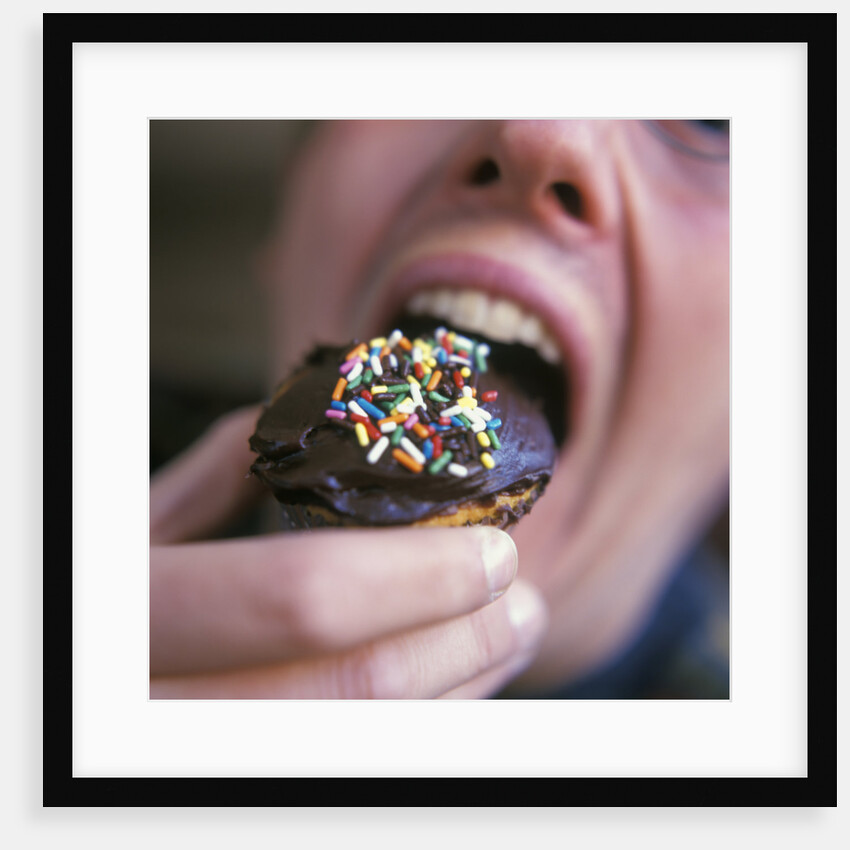 Man Eating Cupcake with Chocolate Frosting by Anonymous