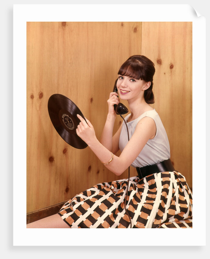 1950s Teenage Girl Talking On Telephone And Holding LP Record by Anonymous