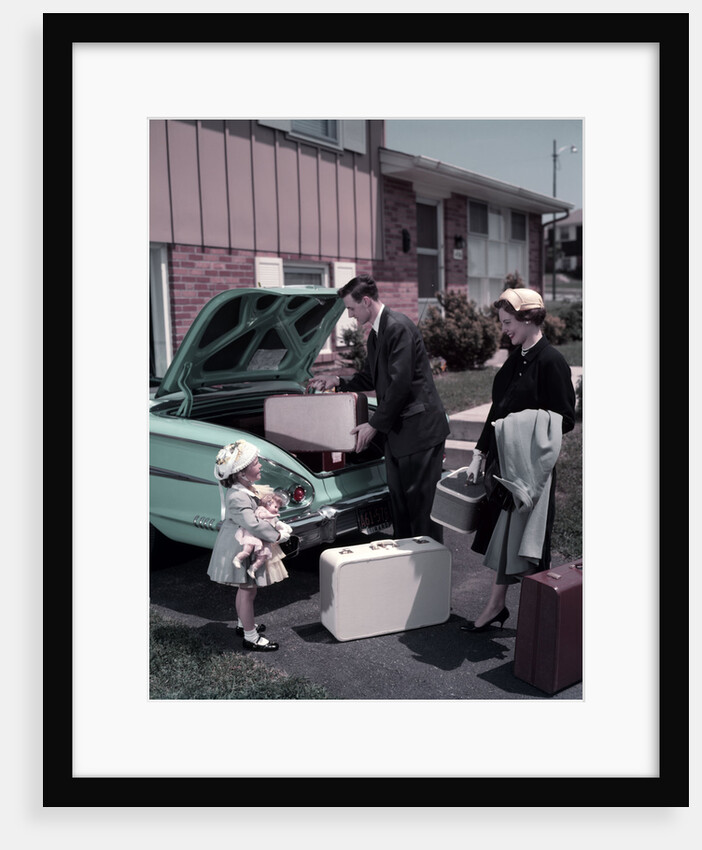 1950s Family Mother Father Daughter In Front Of Suburban House Packing Luggage In Car For Vacation by Anonymous