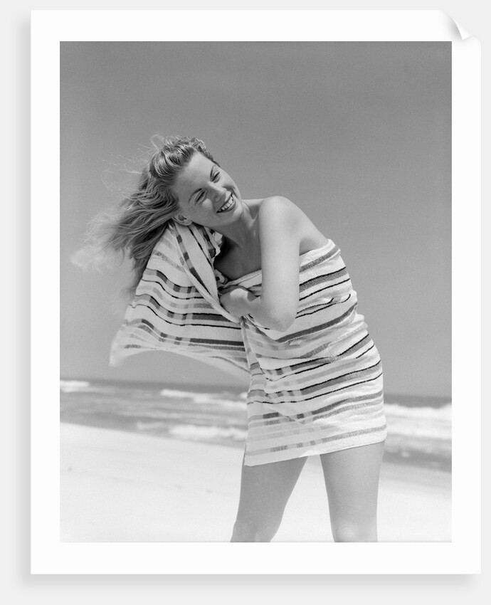 1950s 1960s Woman Wrapped In Stripped Towel Drying Hair On Beach Smiling by Anonymous