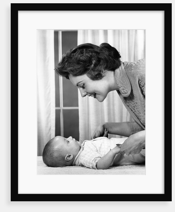 1950s 1960s Mother At Baby Lying On Table Indoor by Anonymous