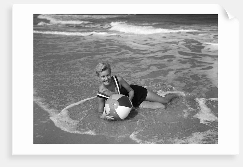 1960s Woman In Bathing Suit Lying In The Surf Holding A Beach Ball Outdoor by Anonymous