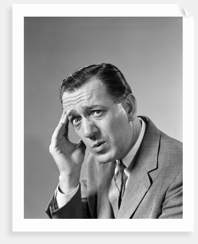 1960s Portrait Man In Suit and Tie With Wrinkled Brow Wincing and Holding Forehead by Anonymous