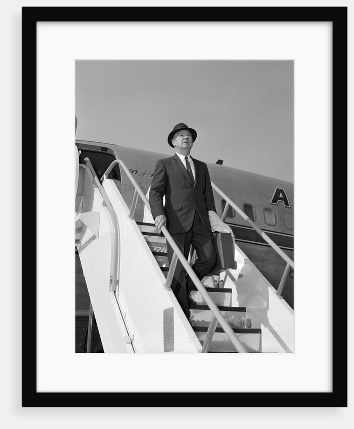 1960s Businessman Deplaning From Airplane Wearing Hat And Carrying Overcoat And Briefcase by Anonymous