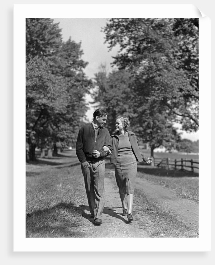1930s 1940s Young Teen Couple Boy Girl Strolling Down Autumn Country Lane Arm In Arm by Anonymous