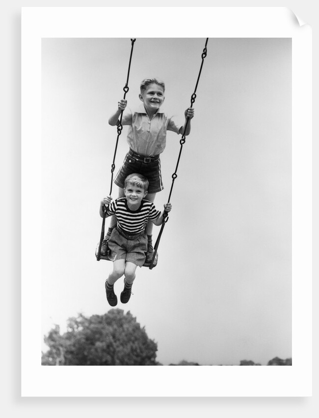 1930s Two Boys Sitting Standing On Playground Swing by Anonymous