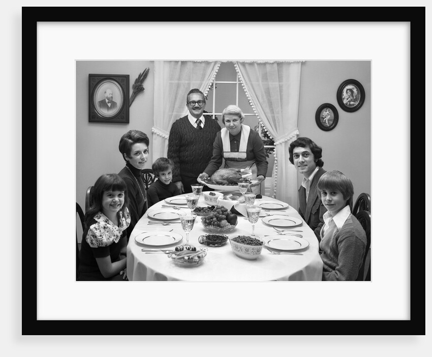 1970s 3 Generation Family Sitting Dining Room Table Grandmother Setting Down Turkey Platter by Anonymous