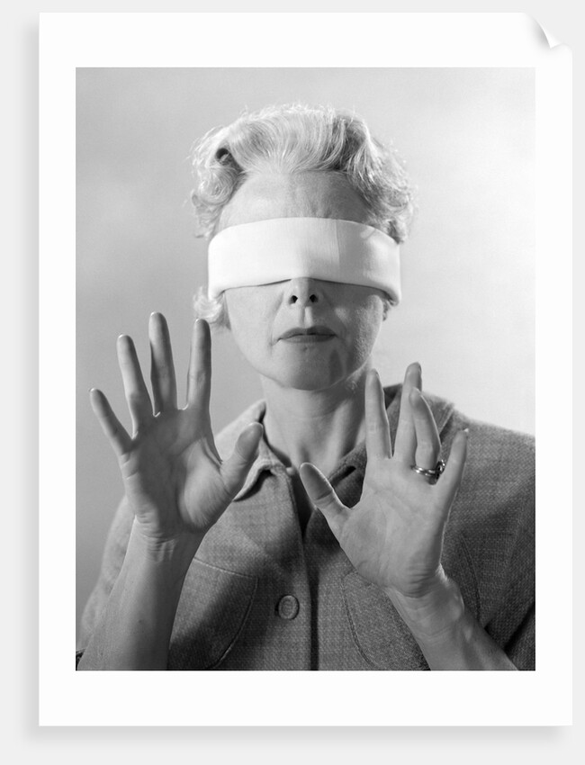 1960s Elderly Woman Wearing Blindfold Holding Up Her Hands by Anonymous