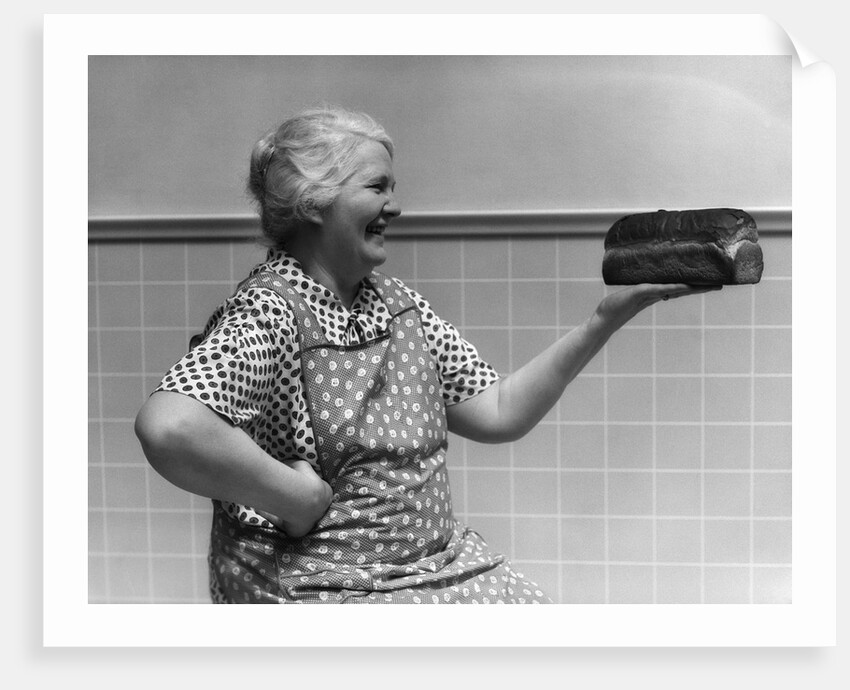 1930s 1940s Grandmother In Apron Admiring Loaf Of Freshly Baked Bread by Anonymous