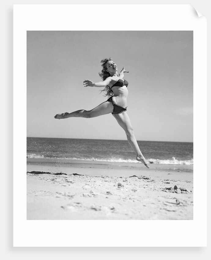 1950s Woman In Bikini Running And Jumping On The Beach Smiling by Anonymous