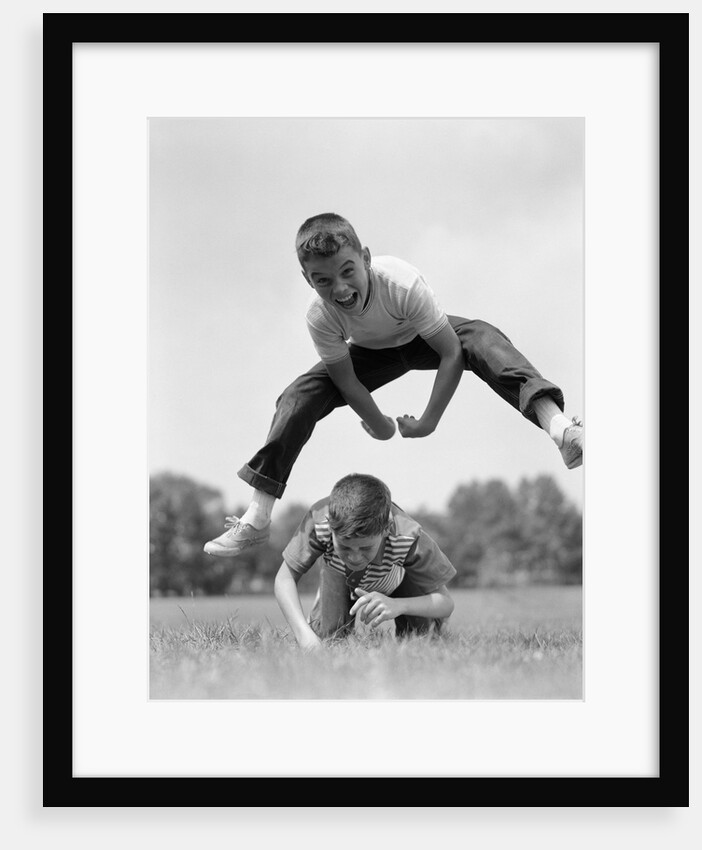 1960s Retro Boys Playing Leap Frog Outside Sky Grass Jump Jumping Crouching by Anonymous