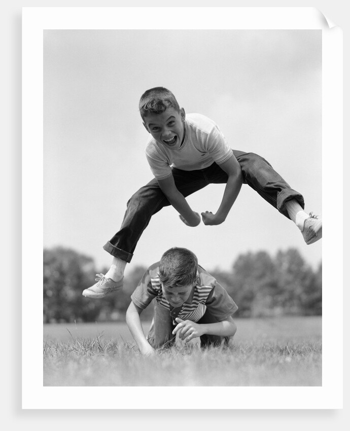 1960s Retro Boys Playing Leap Frog Outside Sky Grass Jump Jumping Crouching by Anonymous