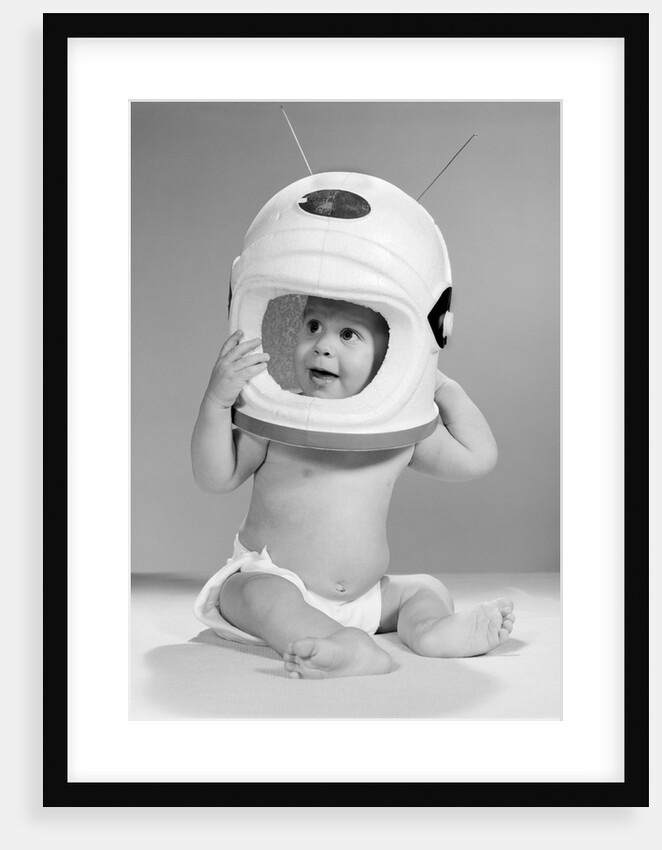 1960s Baby In Diaper Seated Holding Astronaut Helmet With Antennae On Head by Anonymous