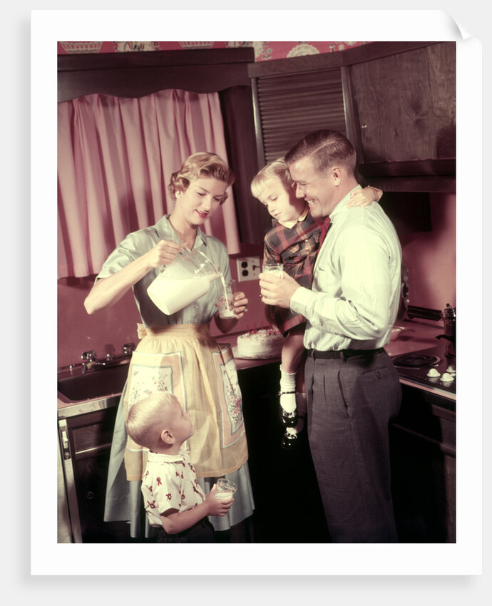 1950s Family In Kitchen Mother Pouring Milk From Pitcher For Dad And Kids by Anonymous