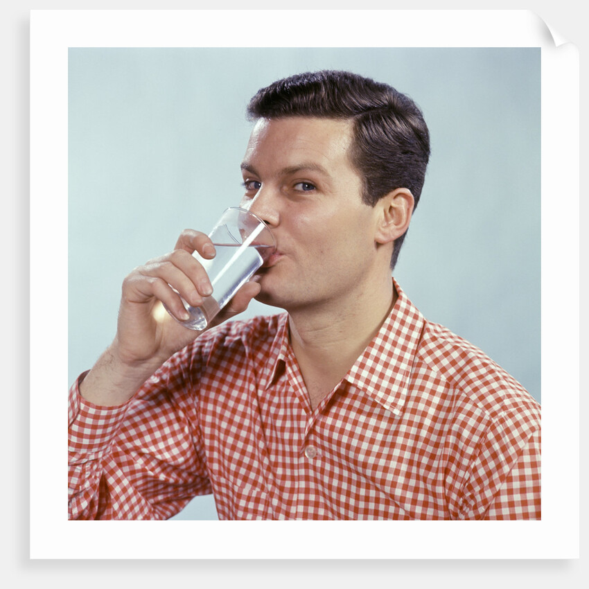 1960s Man Drinking Glass Water Wearing Red Checkered Shirt by Anonymous
