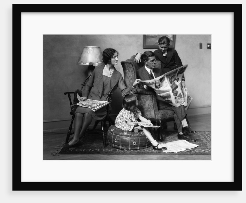 1920s Family of Four Mother Father Son Daughter in Living Room Reading Newspaper Together by Anonymous