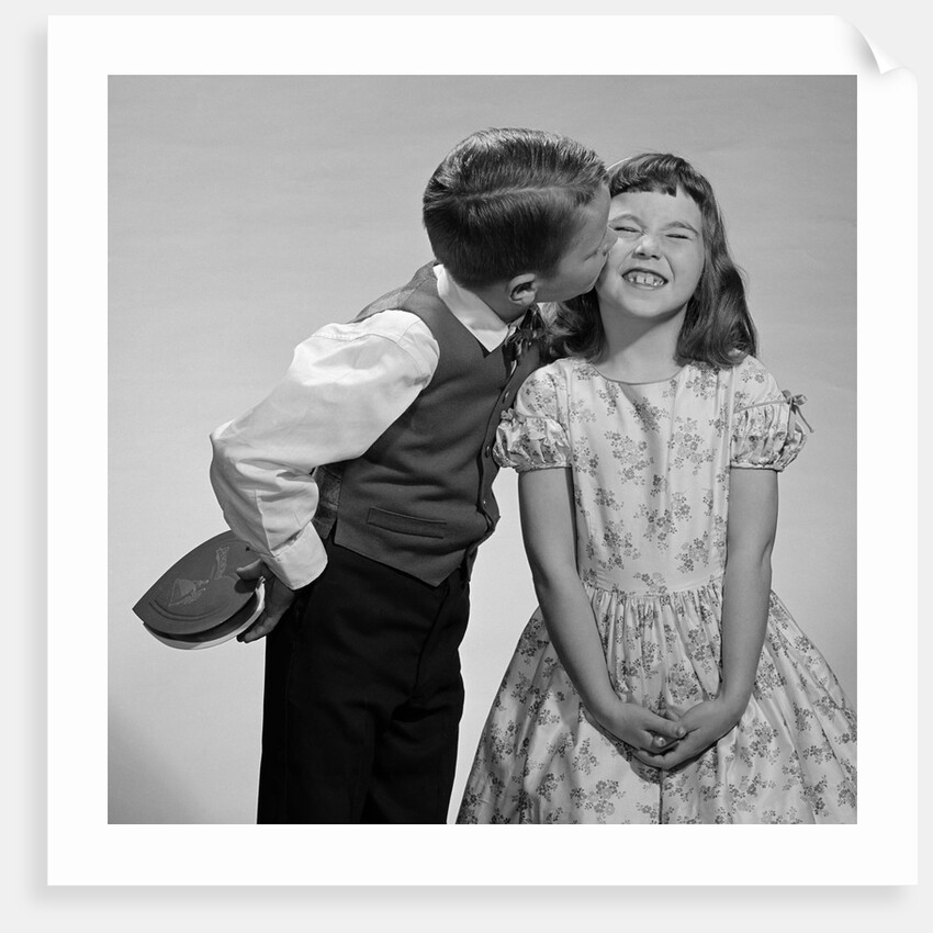 1950s 1960s Boy In Vest and Bow Tie Holding Valentine Candy Kissing Cheek Of Girl Making A Face by Anonymous