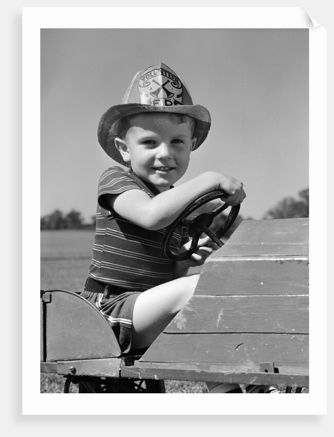 1940s Boy Playing Fireman In Toy Fire Truck Wearing Fireman's Safety Hat Holding Steering Wheel by Anonymous