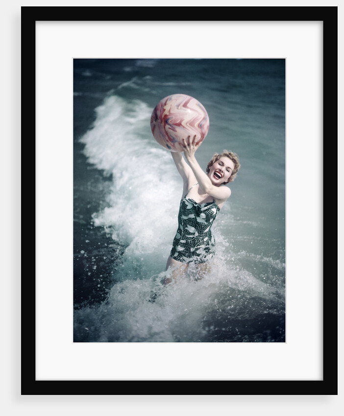 1950s Woman Jumping In Surf Holding Up Beach Ball by Anonymous