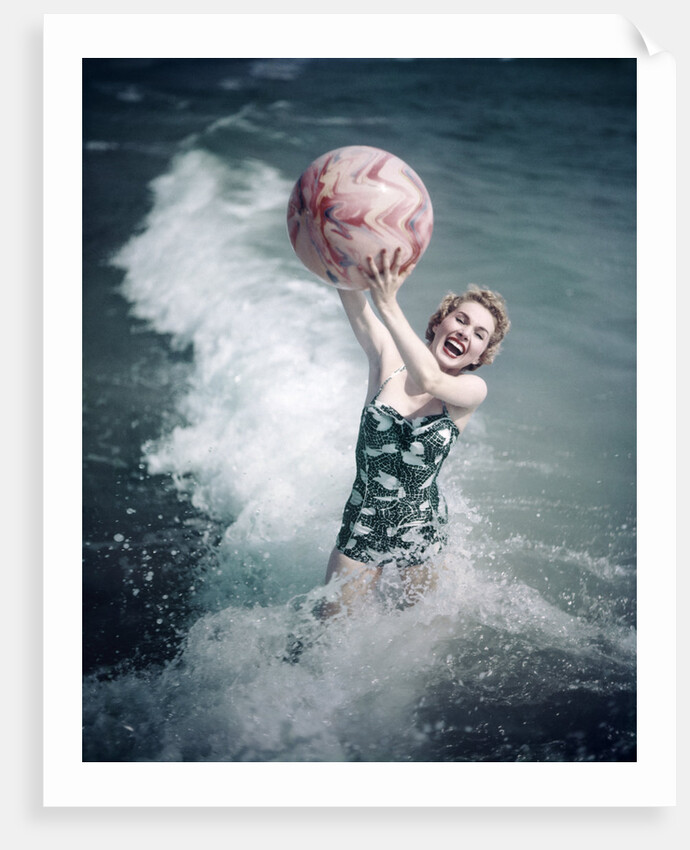 1950s Woman Jumping In Surf Holding Up Beach Ball by Anonymous