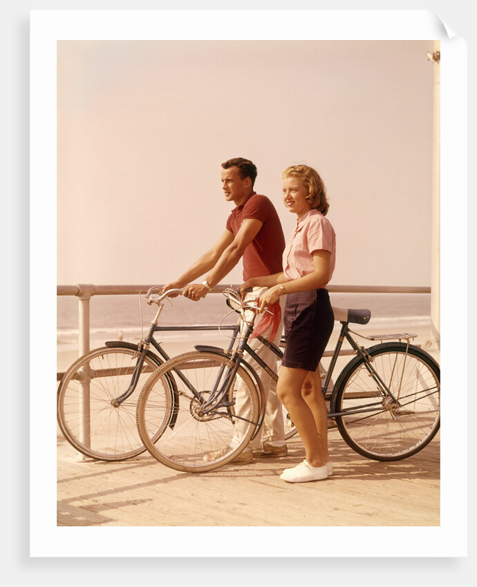 1950s 1960s Teen Couple Standing By Bikes On Beach Boardwalk by Anonymous