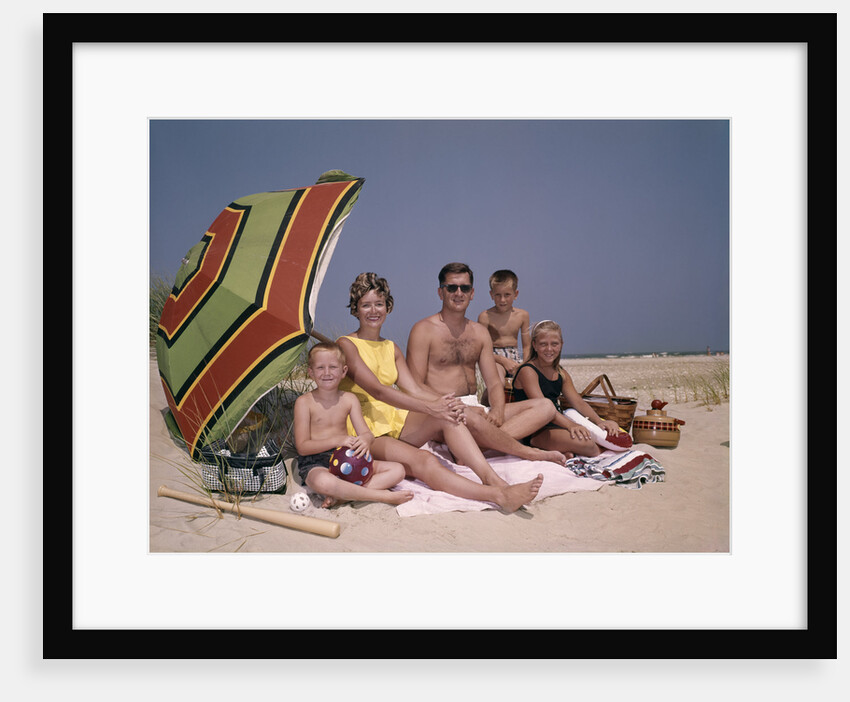 1960s Family On Sunny Beach Under Umbrella With Picnic Basket by Anonymous