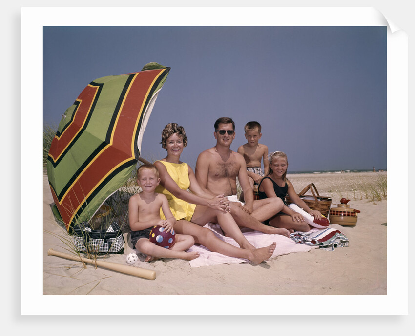 1960s Family On Sunny Beach Under Umbrella With Picnic Basket by Anonymous
