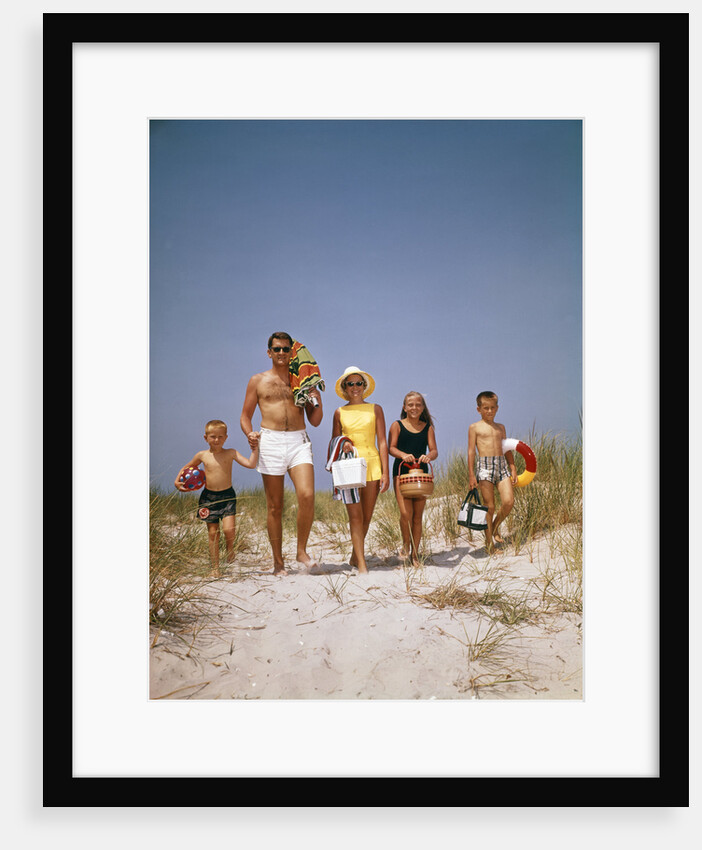 1960s Family Walking Together To The Beach Over Sand Dunes Carry Picnic And Beach Gear by Anonymous