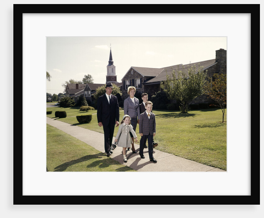 1960s Family Of 5 Walking On Suburban Sidewalk Church Steeple In Background by Anonymous