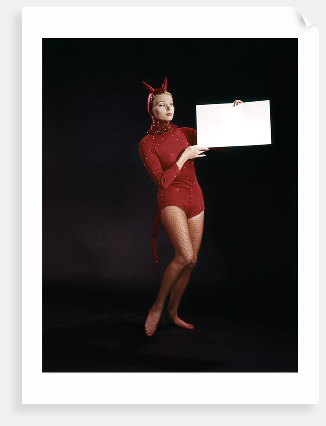 1960s Young Woman In Red Devil Costume Holding Sign Board In Hands by Anonymous