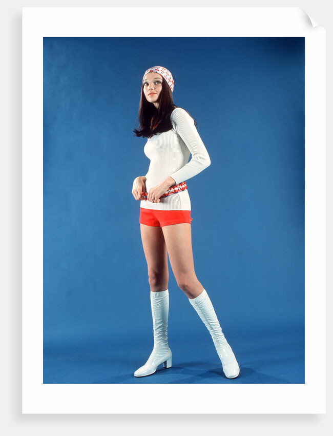 1970s Studio Portrait Woman Teenage Girl In Red Short Shorts And Dancer Fashion White Go-Go Boots by Anonymous