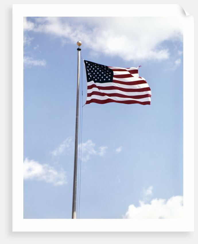 1960s American Flag On Pole Flying Against Blue Sky With Clouds by Anonymous