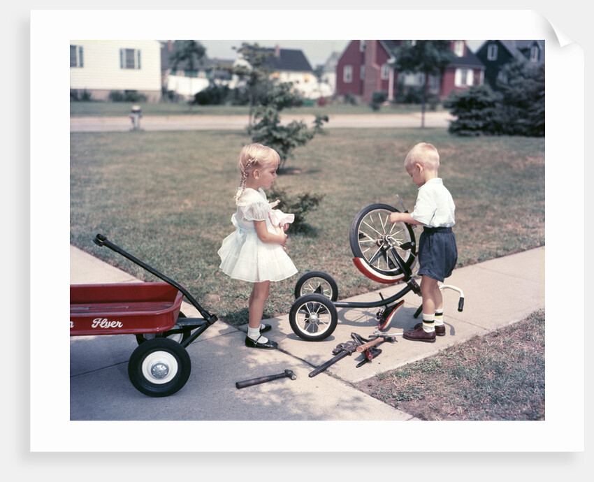 1950s Little Girl Sister Holding Doll Watching Little Boy Brother Repair Tricycle by Anonymous