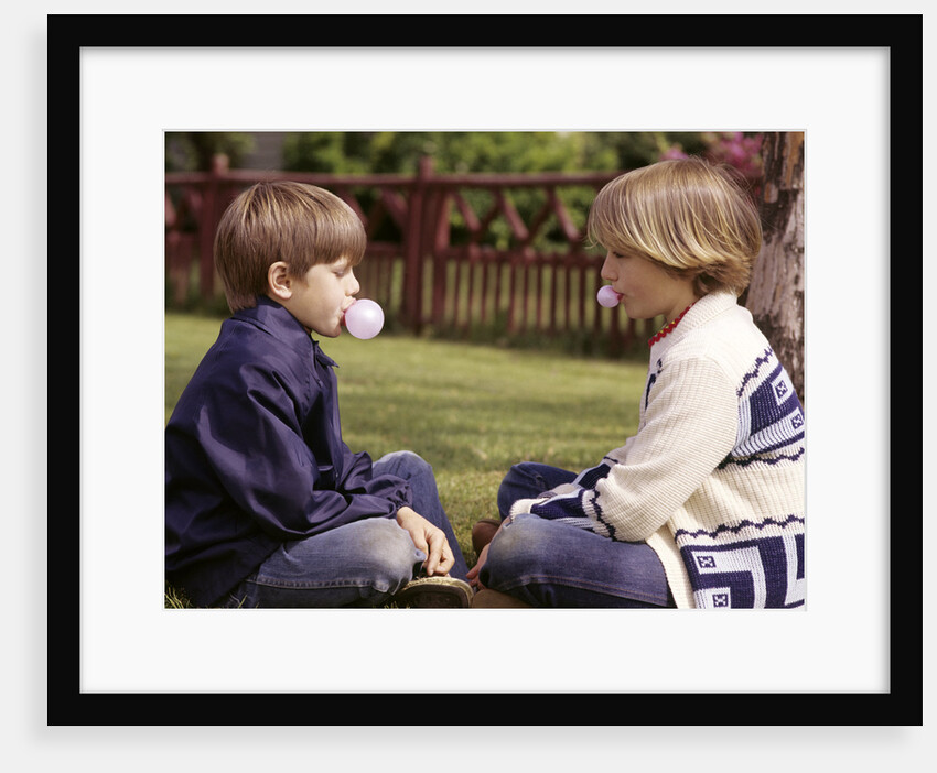 1970s Girls Sit Face To Face Blowing Pink Bubbles With Bubble Gum by Anonymous