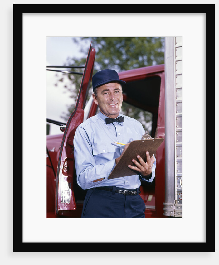 1950s 1960s Repairman In Uniform Holding Clipboard Standing In Open Door Of Truck Cab by Anonymous