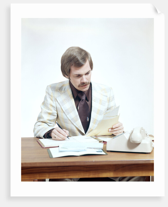 1970s Business Man At Desk Handling Paperwork Office Telephone by Anonymous