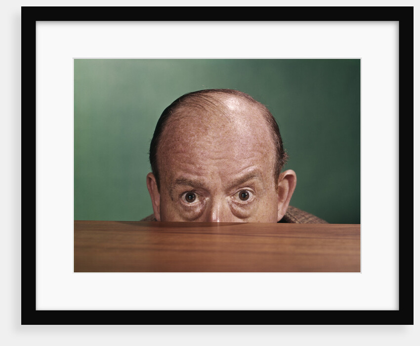 1960s Balding Man Peeking Over Desktop With Only Top Half Of Head Showing by Anonymous