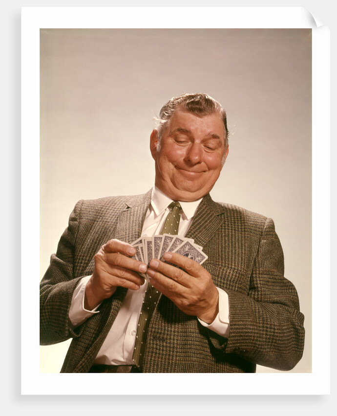 1960s Satisfied Man Looking At Hand Of Playing Cards by Anonymous