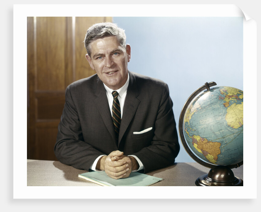1960s Portrait Man Businessman Sitting At Desk Next To Globe Of The Earth by Anonymous