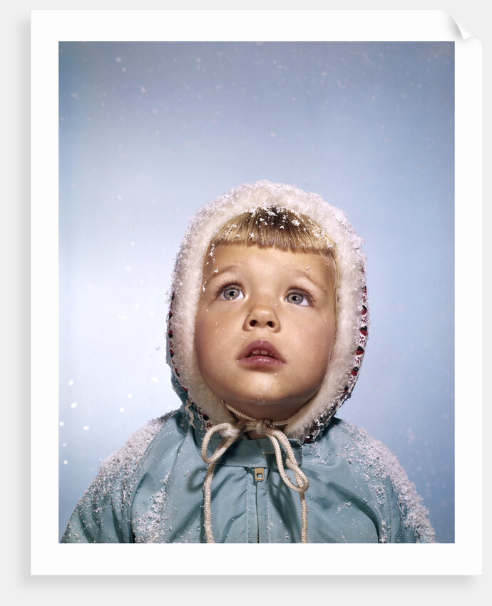 1960s Cold Little Girl In Winter Coat And Hood Looking Up At Falling Snow by Anonymous