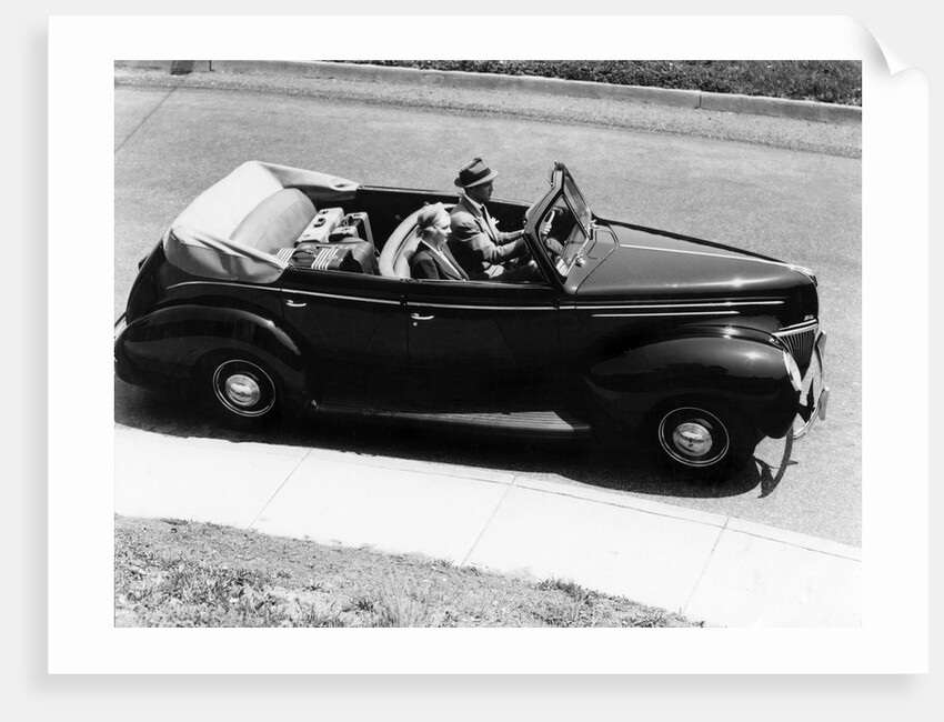 1930s 1940s Couple Driving 1938 Convertible Four Door Sedan Automobile With Luggage In Back Seat by Anonymous