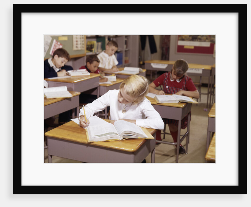 1960s Elementary School Children In Classroom At Desks Working With Books And Papers Boy Girl by Anonymous