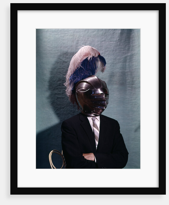 1960s Businessman Wearing 16th Century Medieval Helmet With Visor Closed Blue White Feather by Anonymous